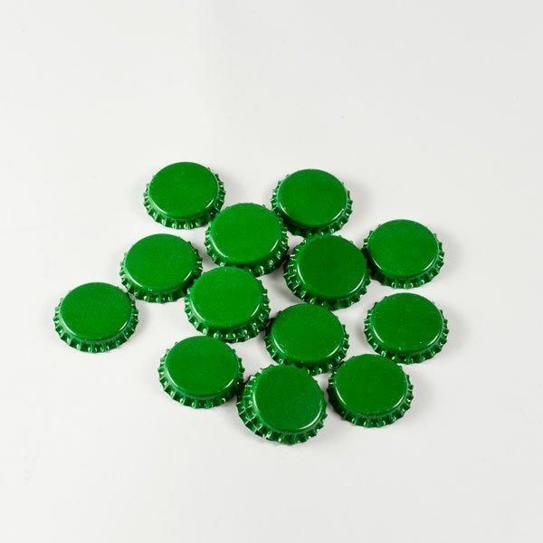 A bunch of green bottle caps on a white surface