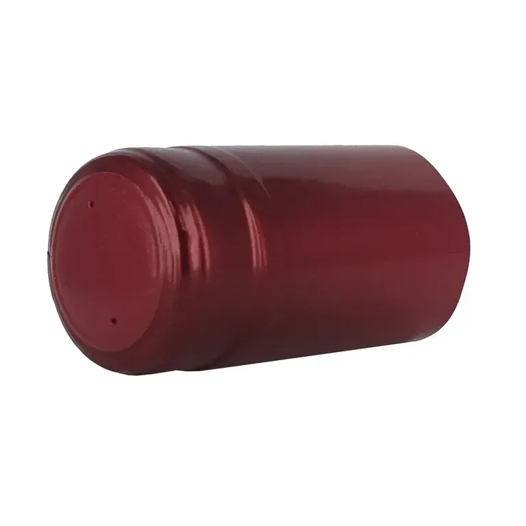 A close up of a red plastic bottle cap on a white background.