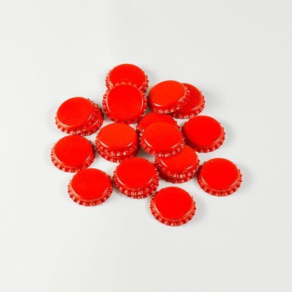 A pile of red bottle caps on a white surface