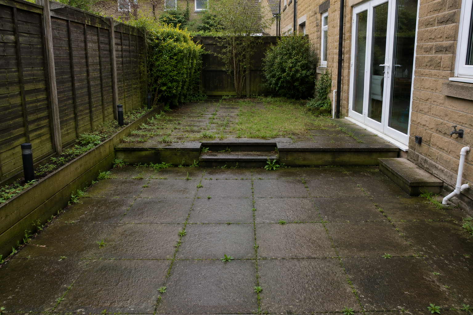 Curved driveway lined with manicured shrubs leading to a large house with a steep roof.