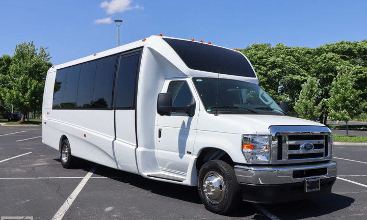 White passenger bus parked outside on a sunny day.