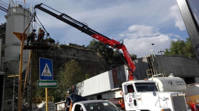 Un camión con una grúa atada a la parte trasera