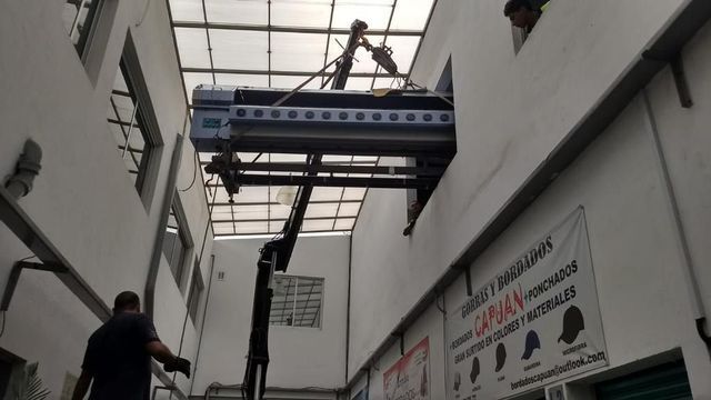 Un hombre está parado frente a un cartel que dice cajay