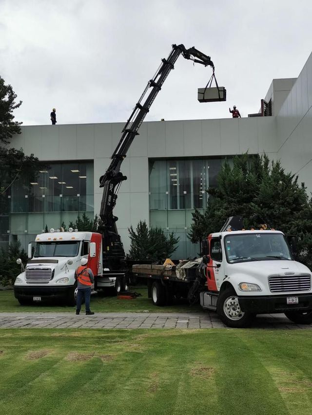 Dos camiones están estacionados frente a un gran edificio.