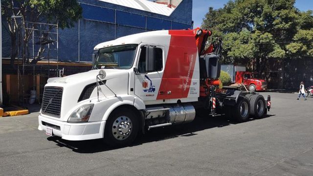 Un camión blanco y rojo está estacionado al costado de la carretera.