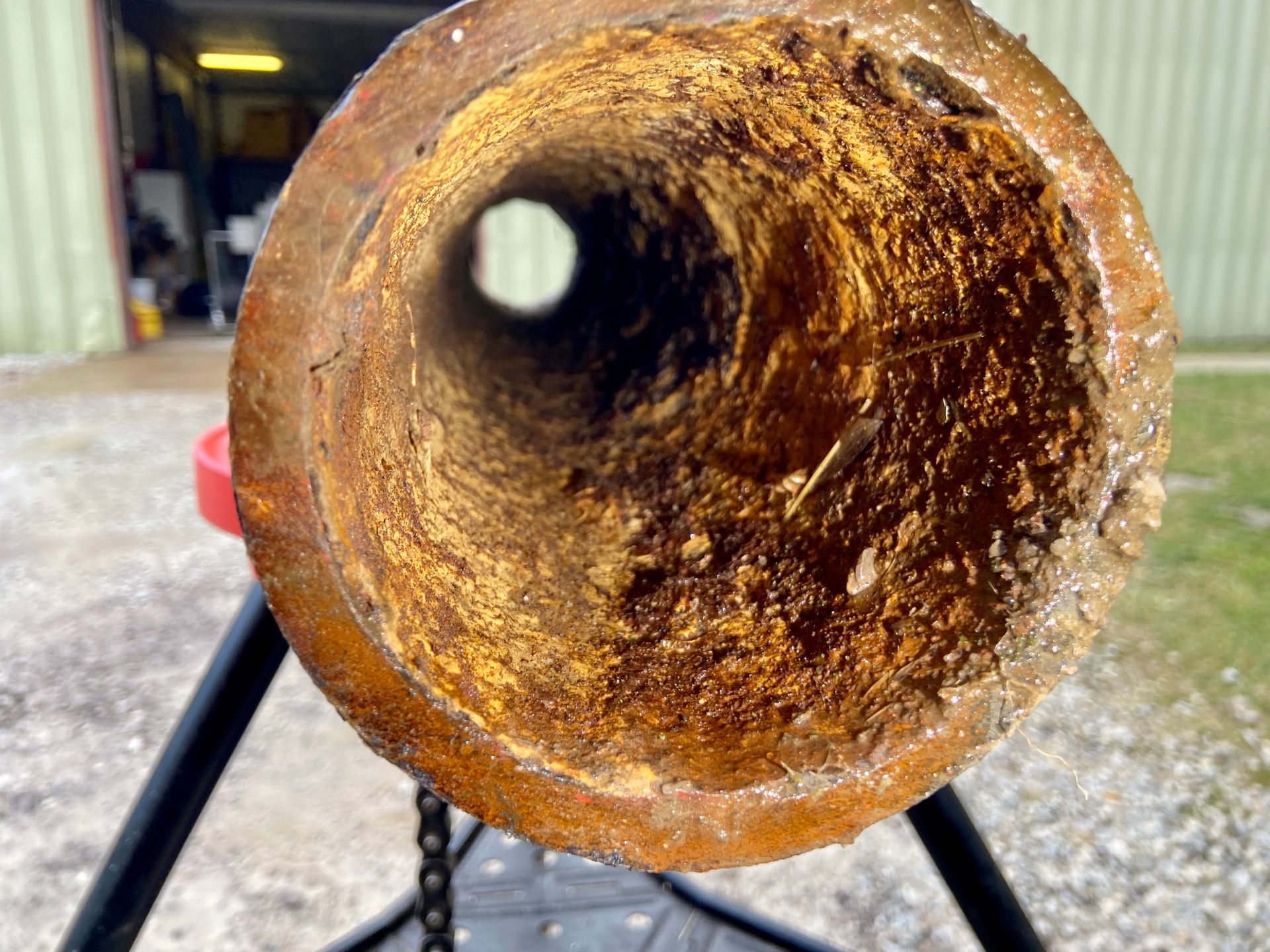 A close up of a rusty pipe with a hole in the middle.