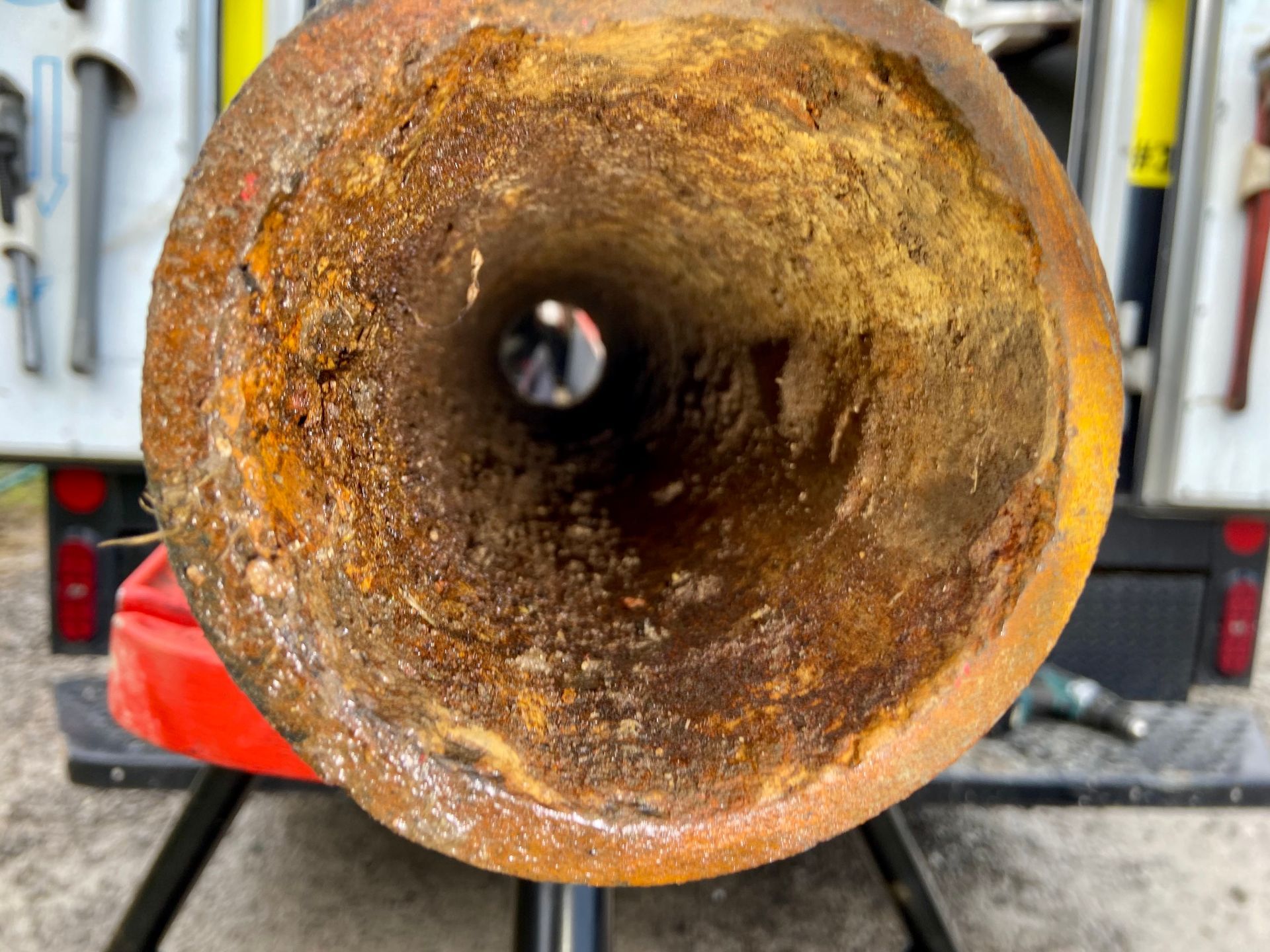 A close up of a rusty pipe with a hole in the middle.