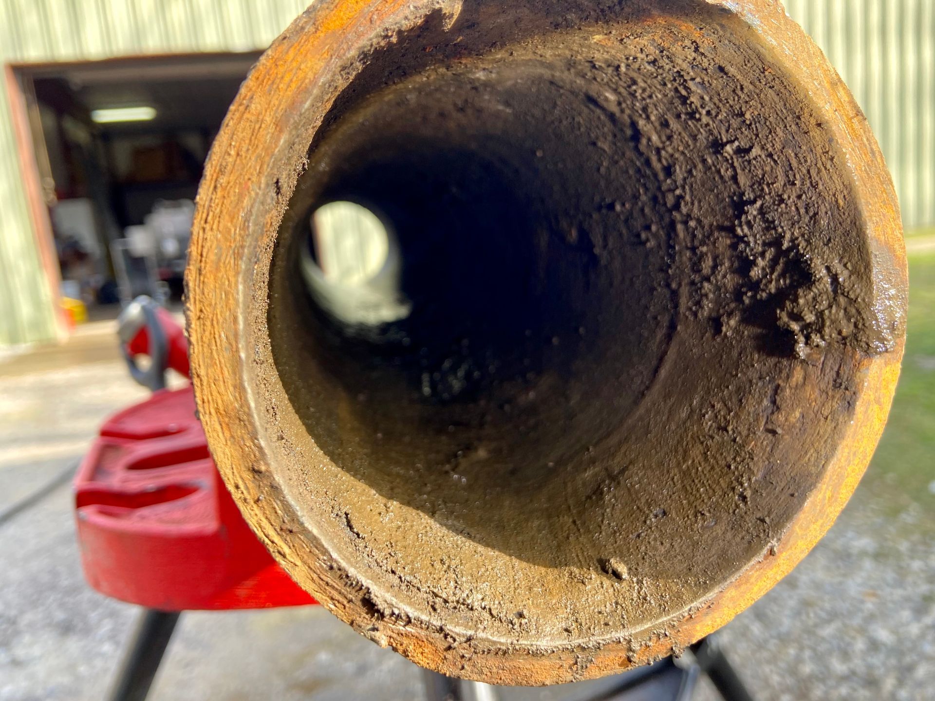 A close up of a rusty pipe with a hole in the middle.
