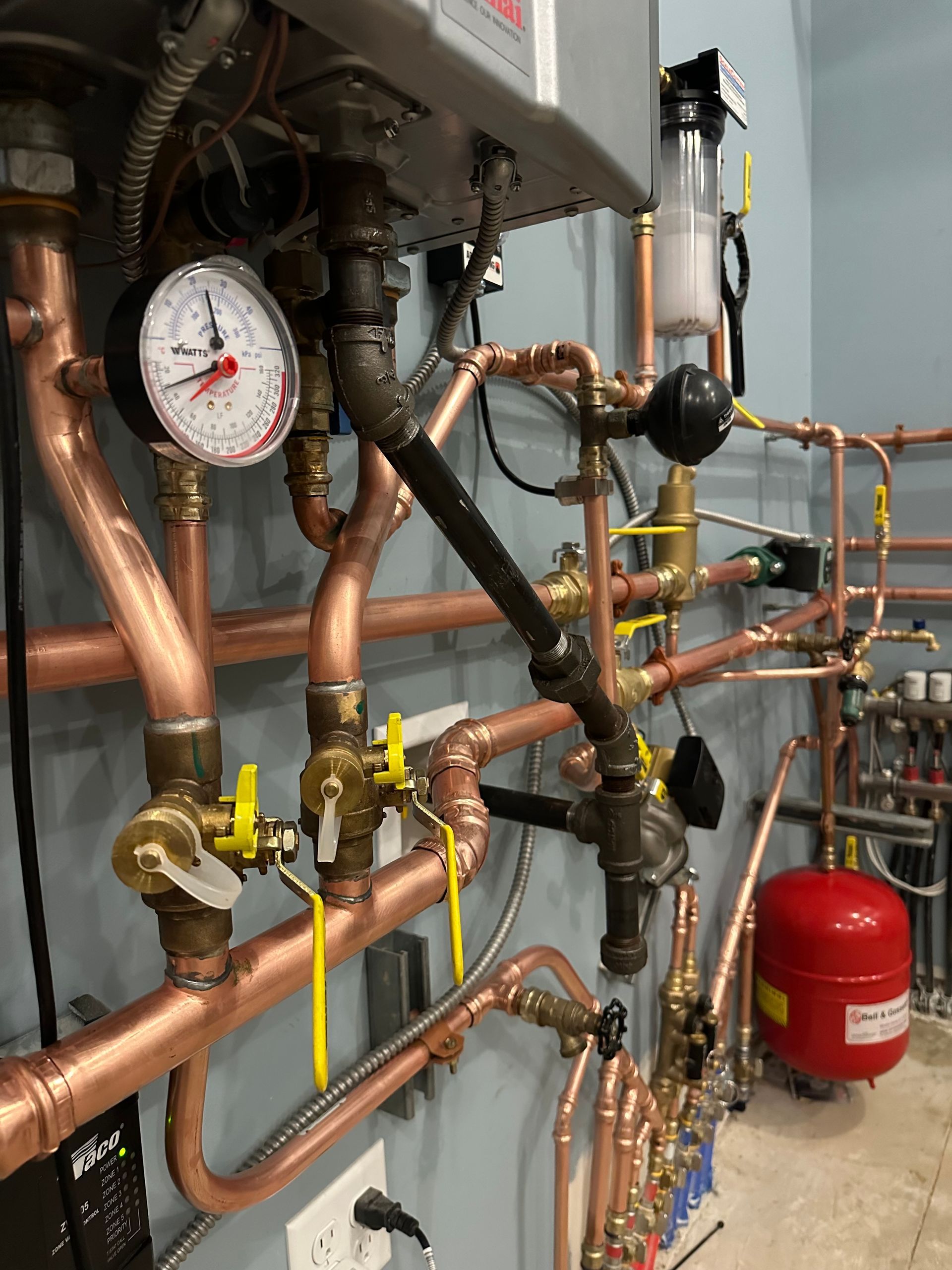 A room filled with lots of copper pipes and gauges.