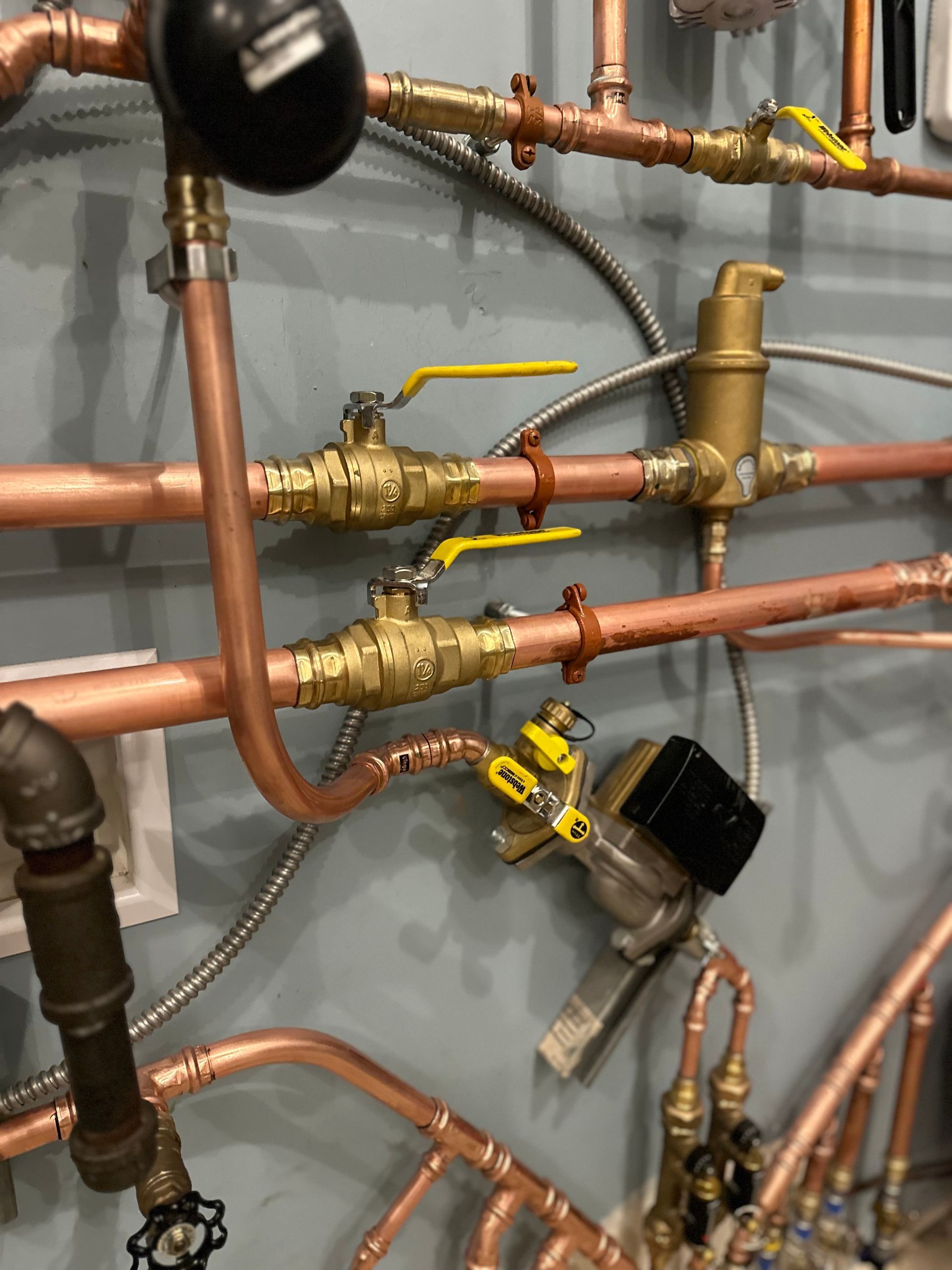A bunch of copper pipes are hanging on a wall.