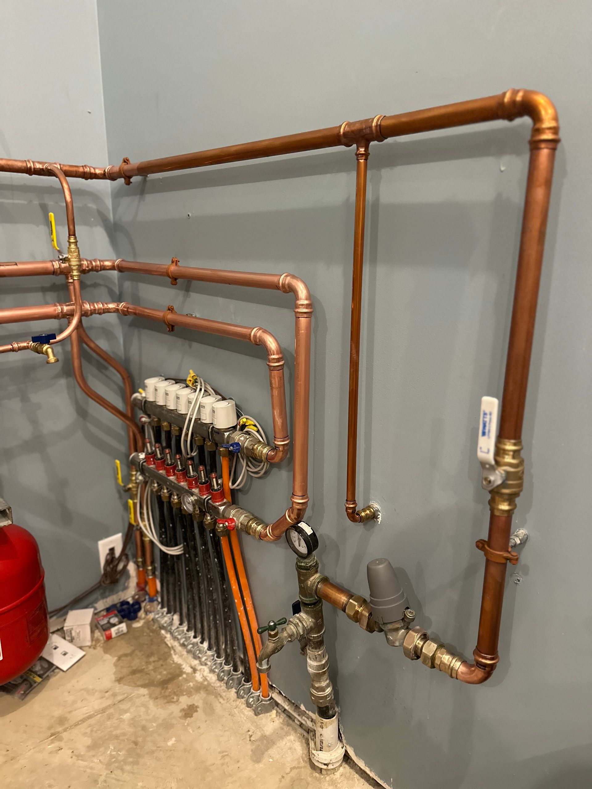 A room with a lot of copper pipes hanging on the wall.