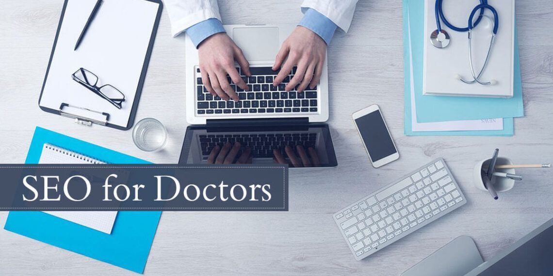 Doctor working on a laptop with a stethoscope, phone and clipboard placed on the side, balancing medical tasks and digital work.