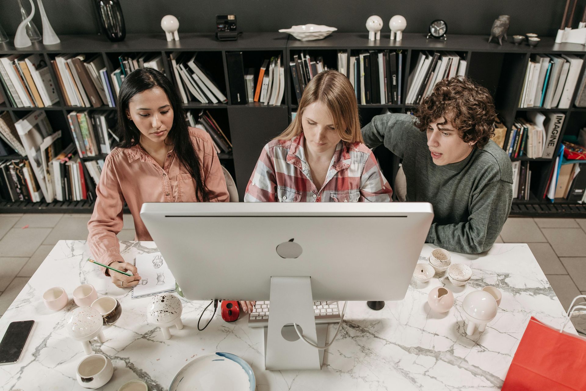 three website designers focused on a computer screen three website designers focused on a computer screen