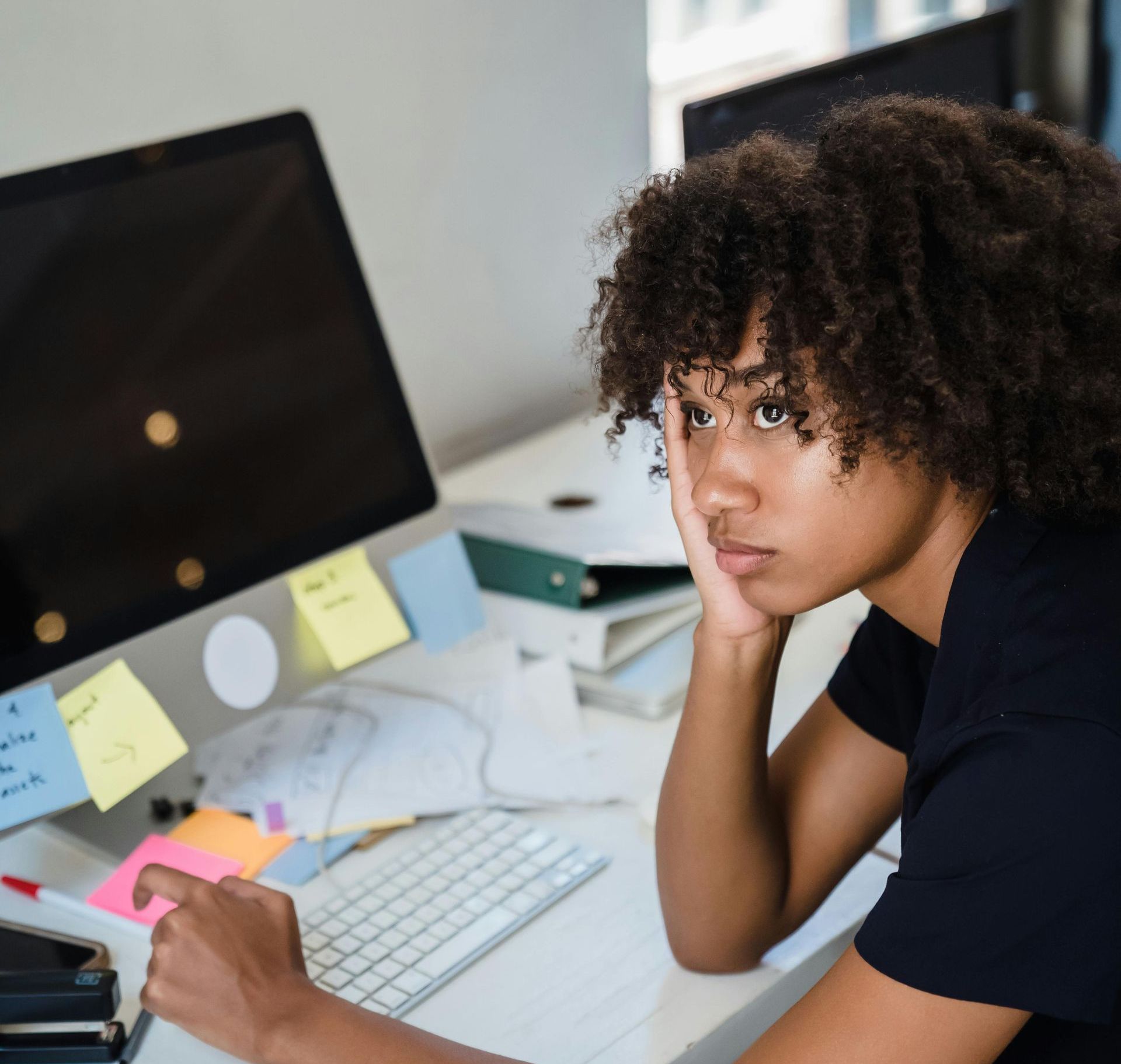 Person sitting in front of a computer, deep in thought, brainstorming solutions to a challenge. Person sitting in front of a computer, deep in thought, brainstorming solutions to a challenge in Atlanta.