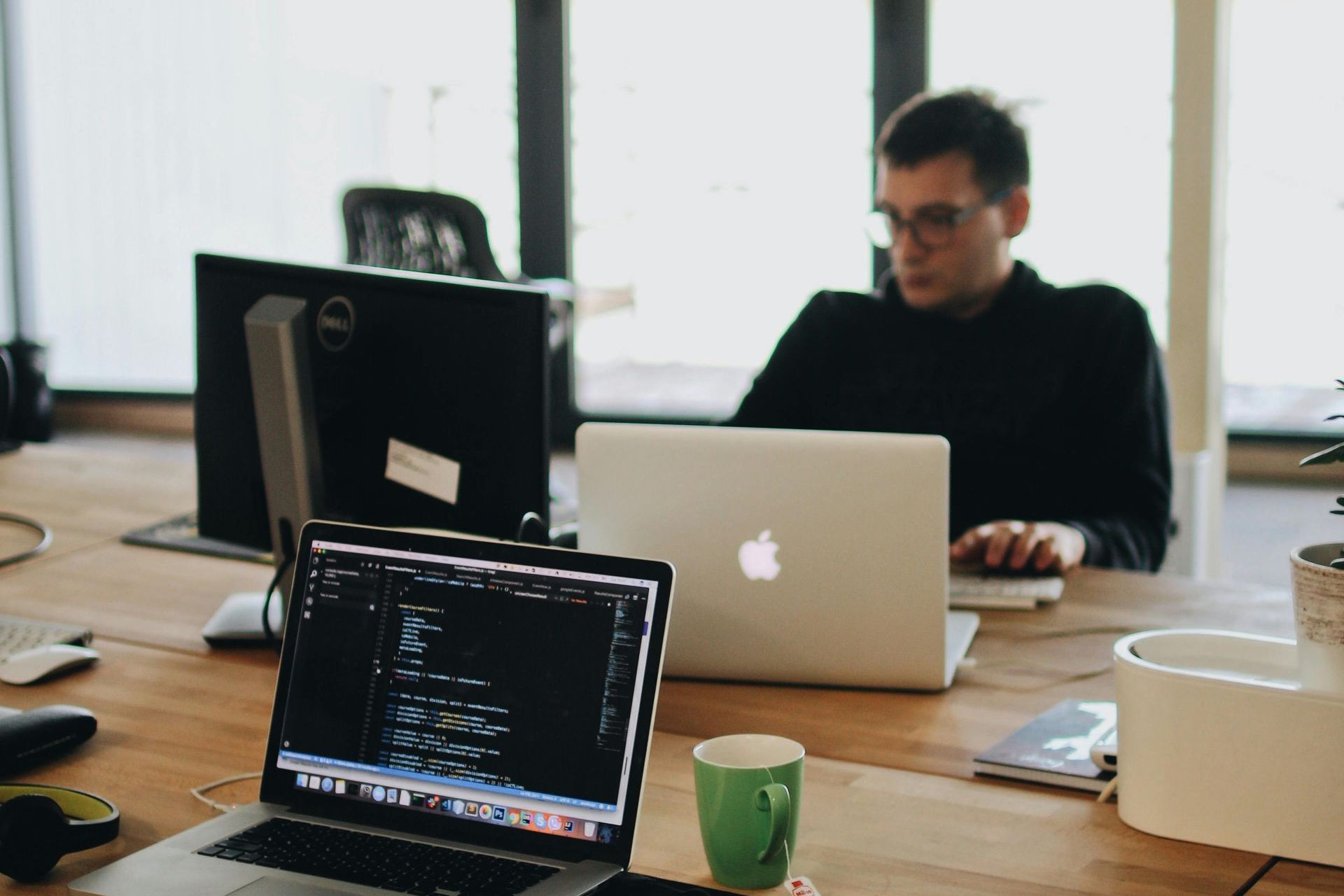 A local website developer focused on working in front of a computer with multiple screens. A local website developer focused on working in front of a computer with multiple screens.