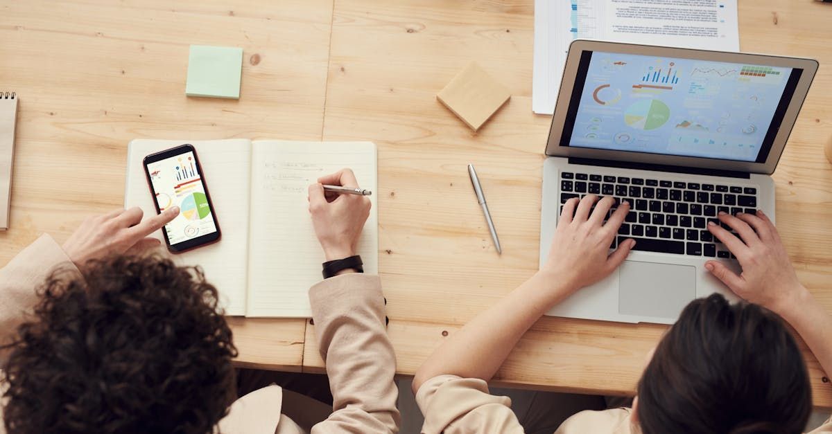 SEO expert reviewing SEO statistics on a laptop and smartphone. SEO expert reviewing SEO statistics on a laptop and smartphone.