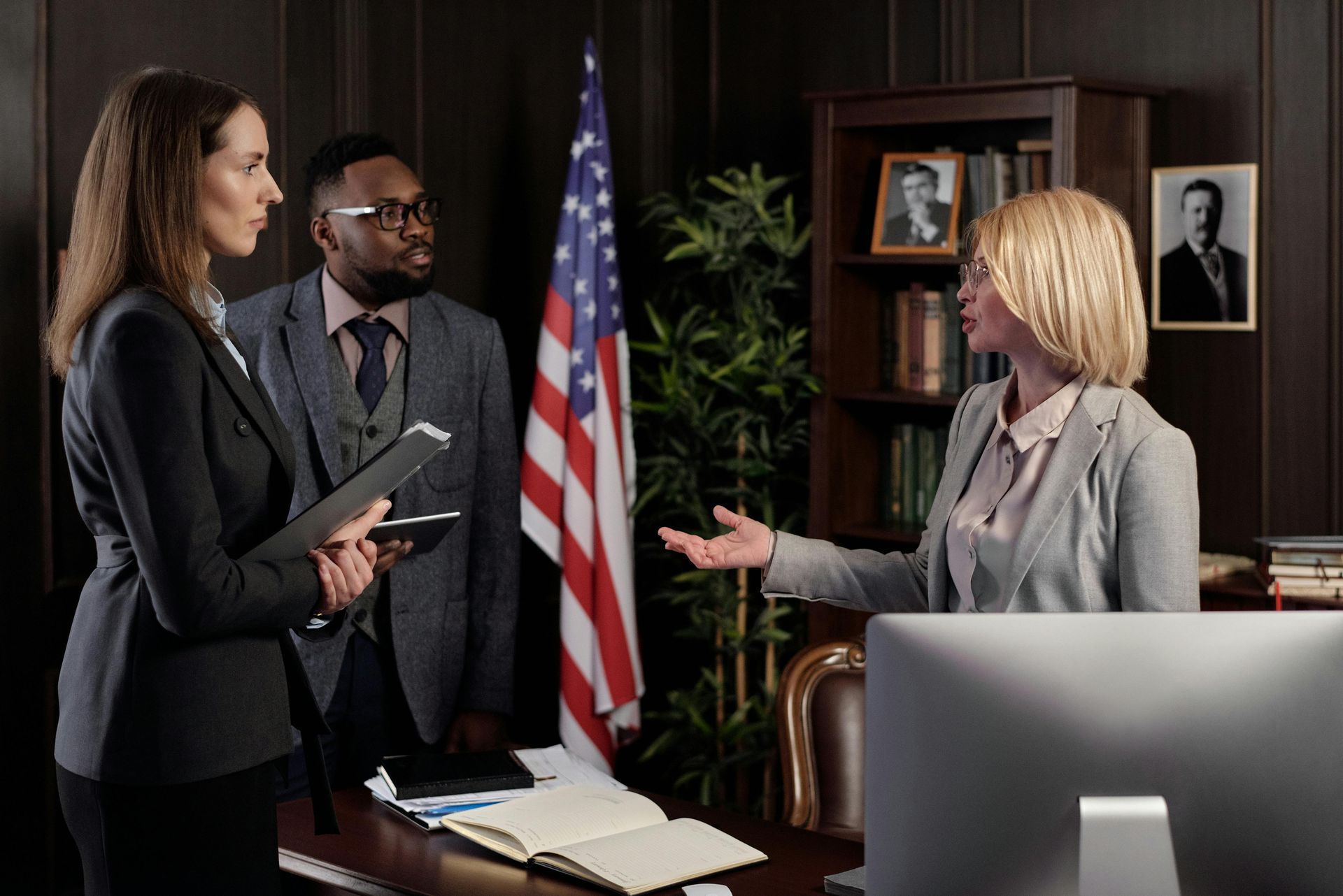 Three injury attorney engaged in discussion inside a law firm, surrounded by legal documents Three injury attorney engaged in discussion inside a law firm office, surrounded by legal documents