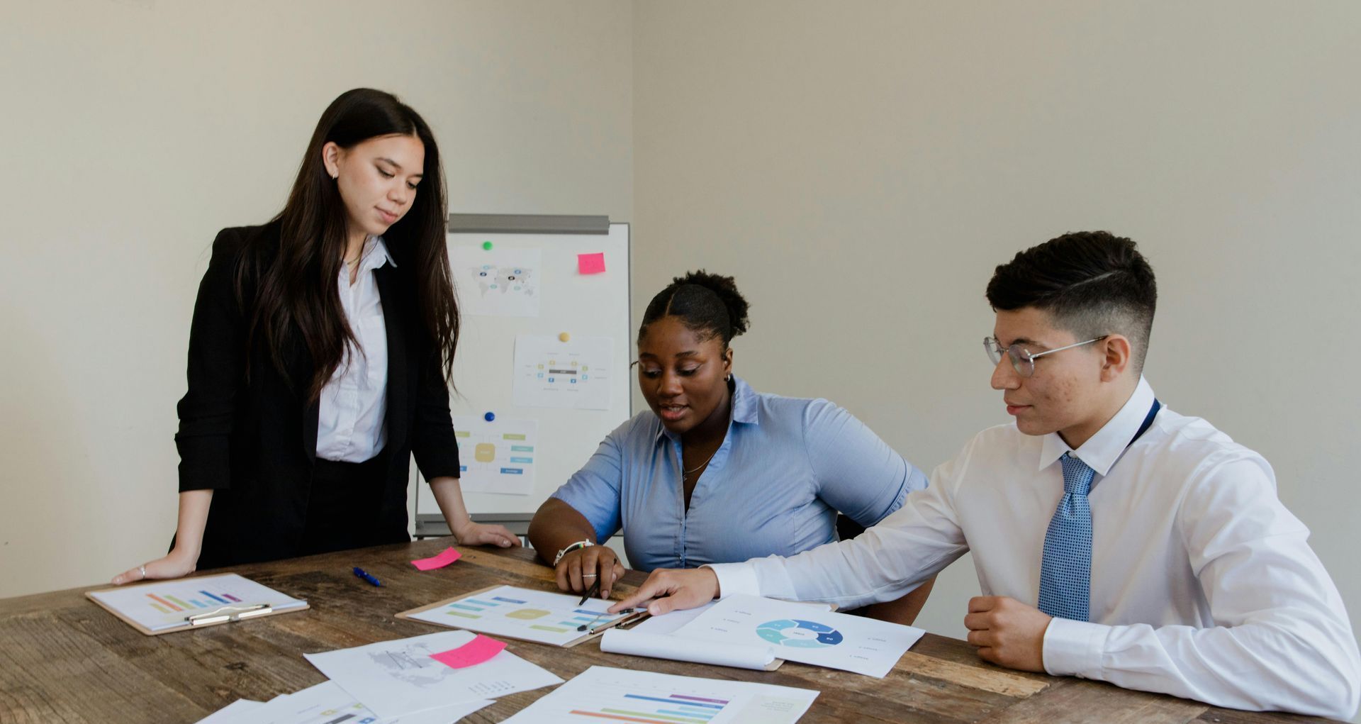 Three professionals having a discussion, reviewing graphs and analytics, collaborating on social media marketing strategies and data-driven insights. Three professionals having a discussion, reviewing graphs and analytics, collaborating on social media marketing strategies and data-driven insights.