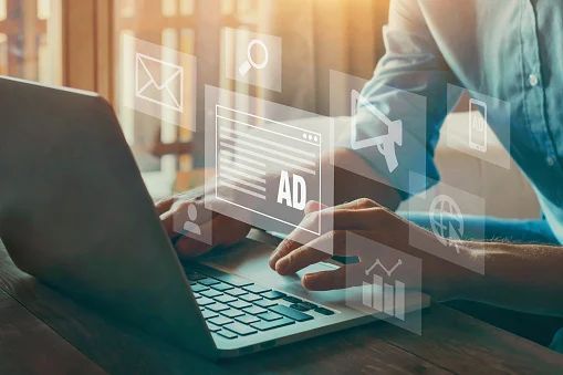 A professional working on a laptop, focused on tasks related to advertising and marketing A professional working on a laptop, focused on tasks related to advertising and marketing