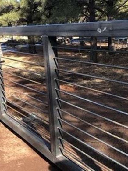 Wooden gate at Lazy B Ranch with a rustic sign and open ranch entrance under a blue sky