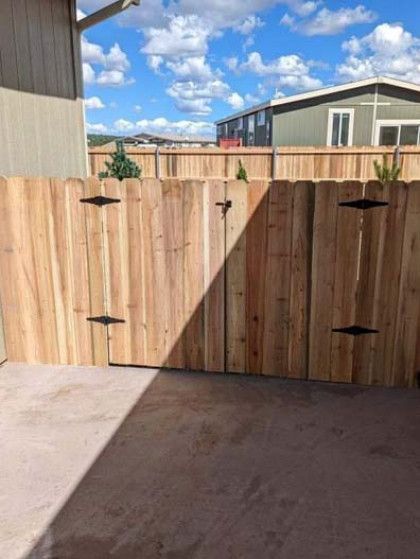 Wooden gate at Lazy B Ranch with a rustic sign and open ranch entrance under a blue sky