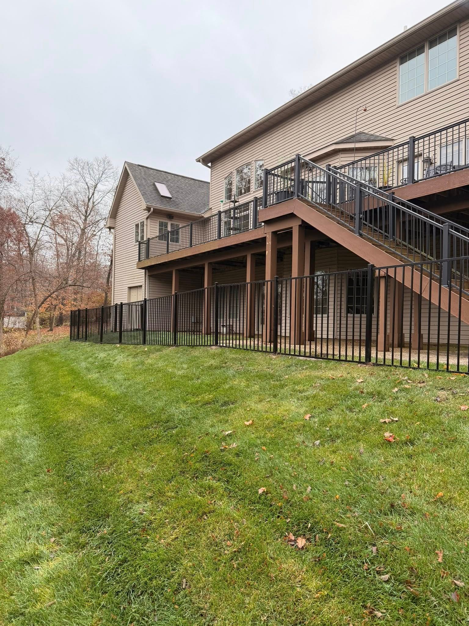 Raised house with stairs and deck above a grassy yard on an overcast day