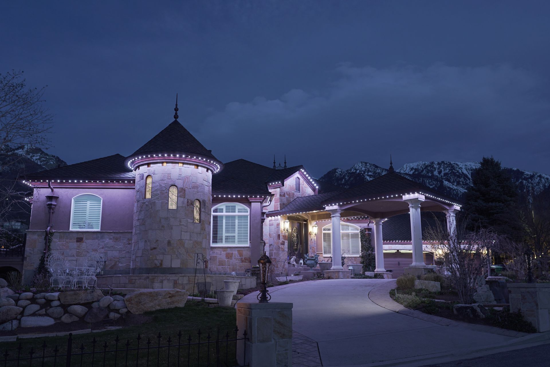 A large house is lit up with christmas lights at night