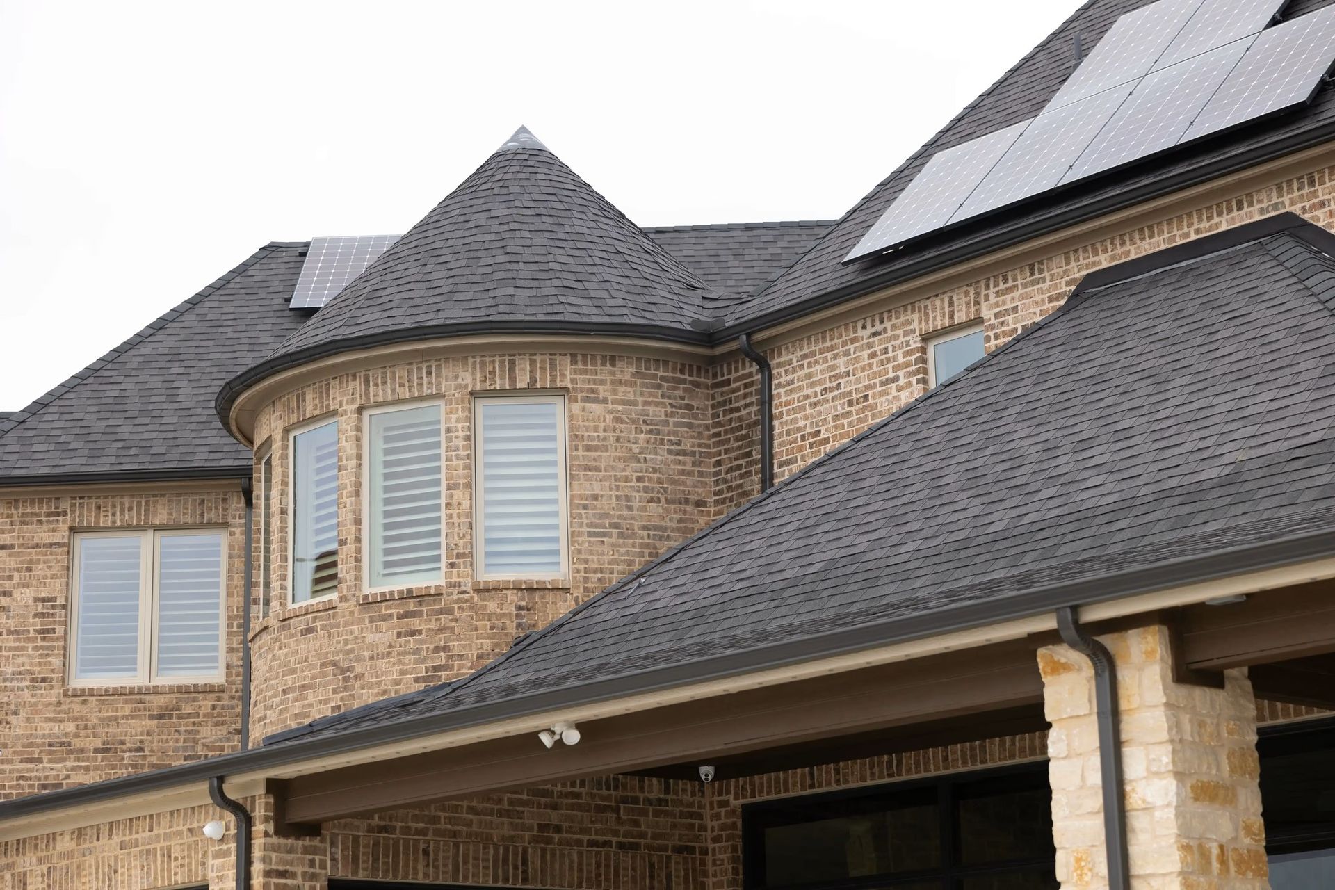 A large brick house with solar panels on the roof.