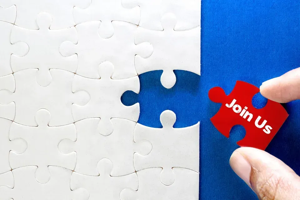 Hand placing a red puzzle piece labeled