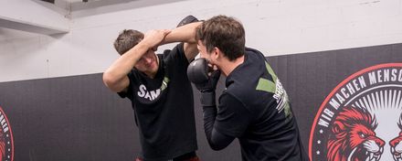 Eine Frau und ein Mann beim Kampfsporttraining
