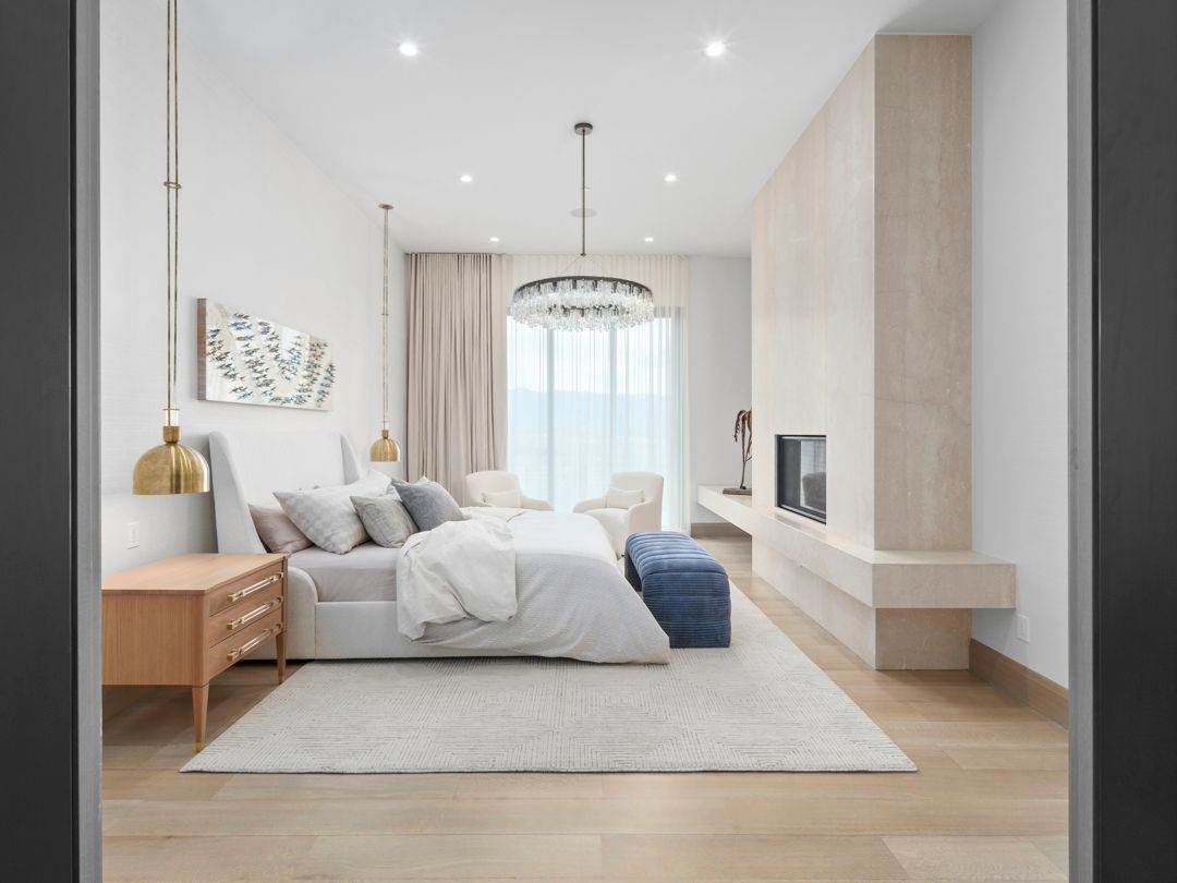 Bright modern bedroom with a bed, wooden nightstands, pendant light, and large window with sheer curtains