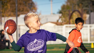 Youth flag football player throwing a football to his teammate