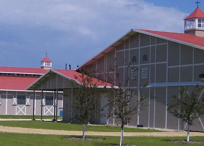 A large building with a red roof is surrounded by trees