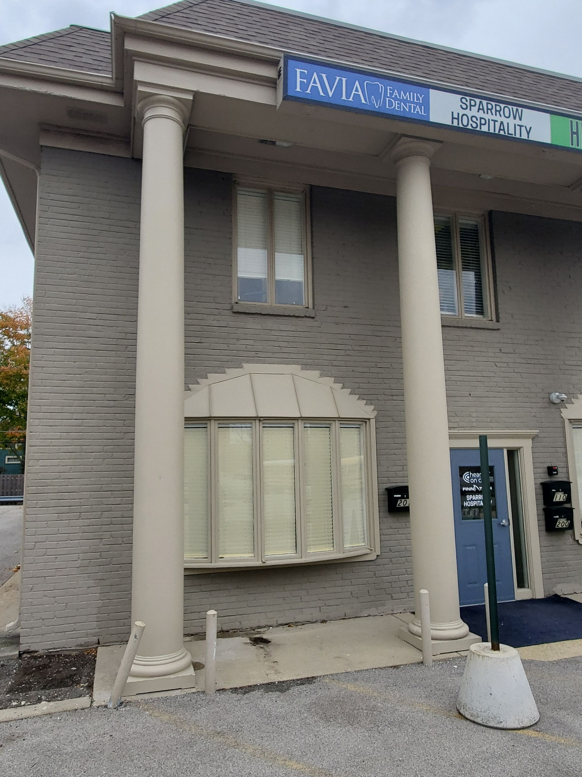 A large brick building with columns and a blue door