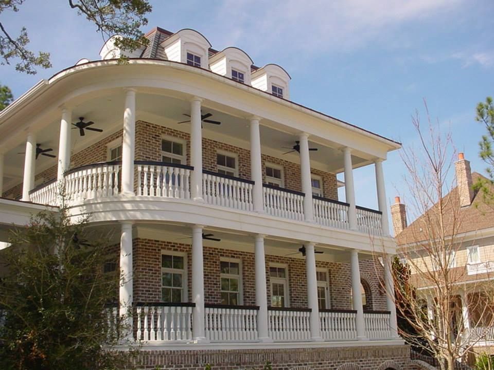 A large brick house with a large porch and balconies