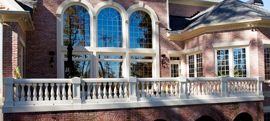 A large brick house with a balcony and lots of windows.