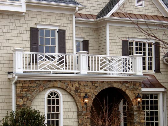 A house with a balcony and shutters on the windows