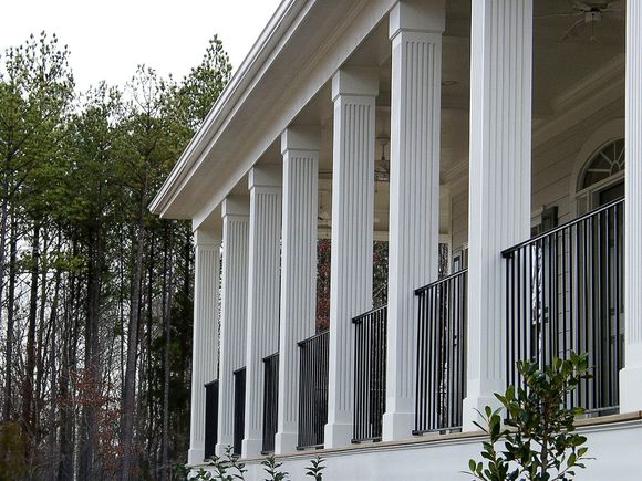 A white building with columns and a black railing