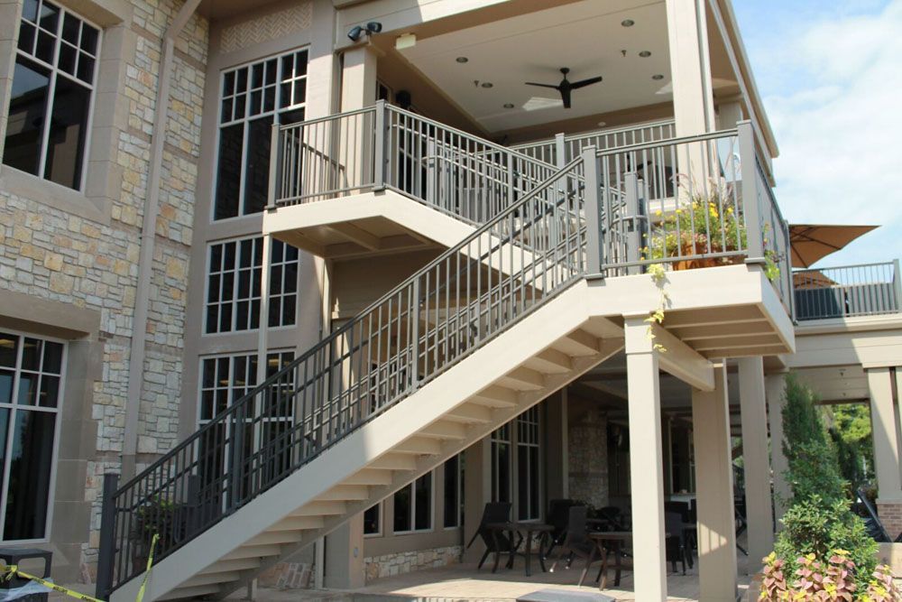 A house with a balcony and stairs leading up to it.