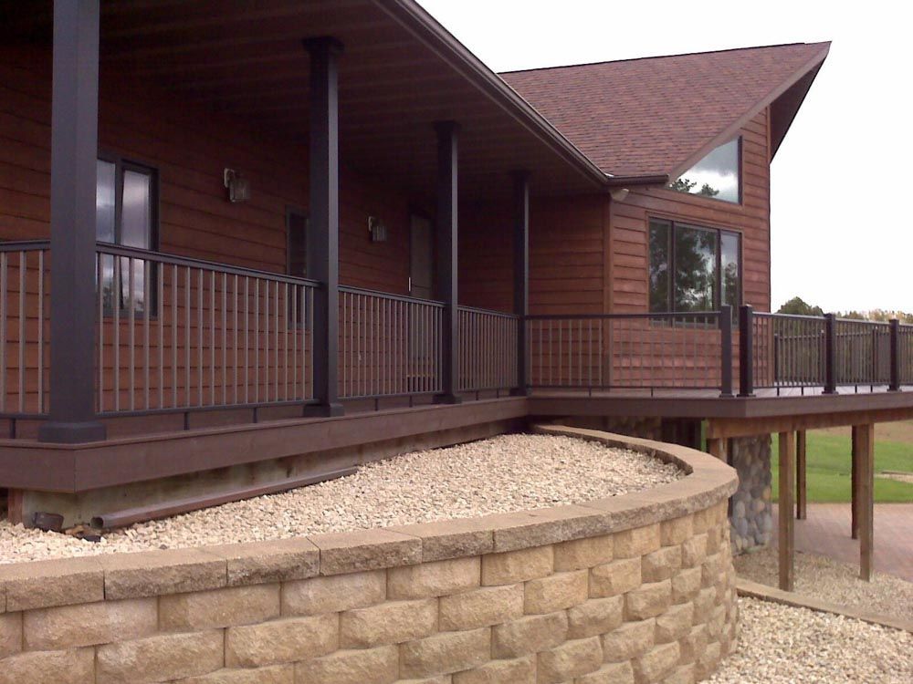 A large house with a large deck and a brick wall