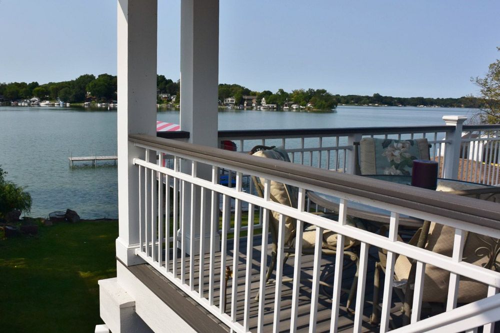 A balcony overlooking a lake with a white railing