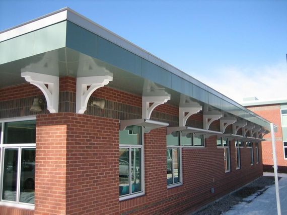 A brick building with a green roof and a lot of windows