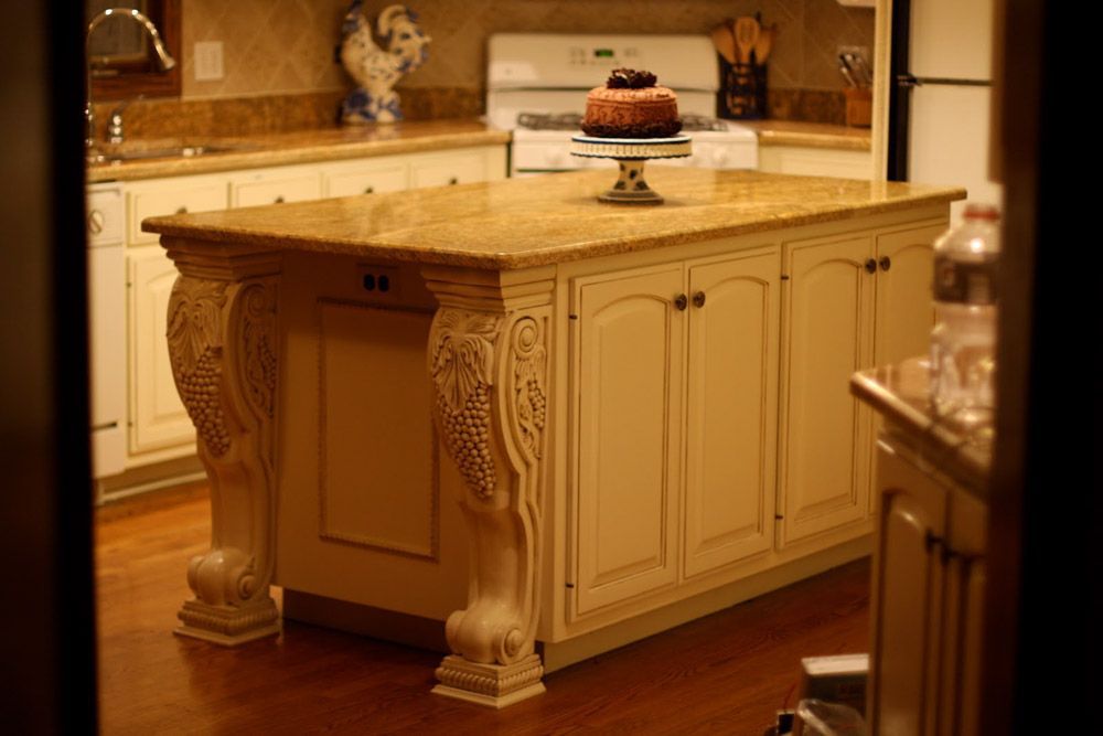 A large island in a kitchen with a cake on top of it.