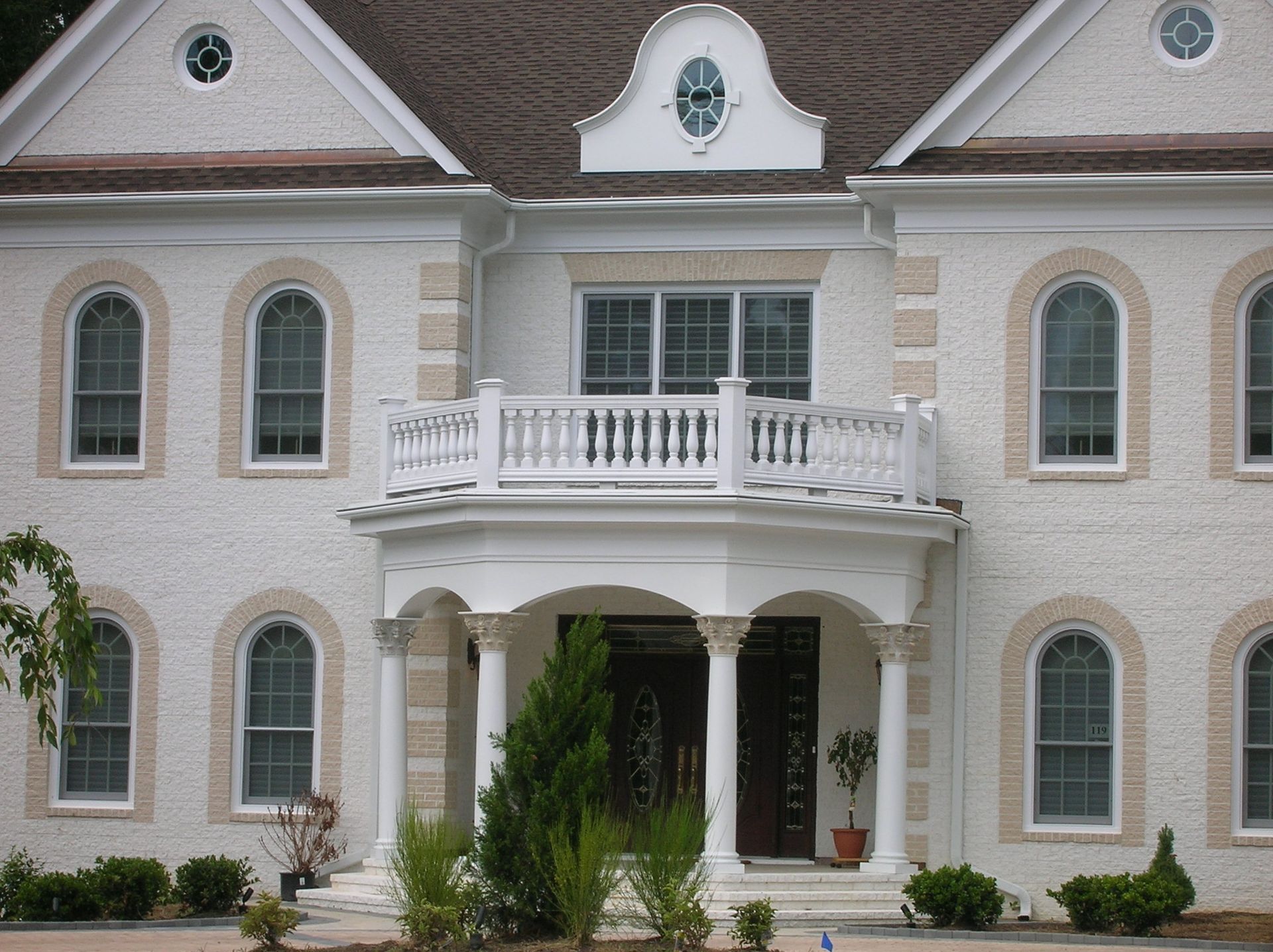 A large white house with a balcony and arched windows