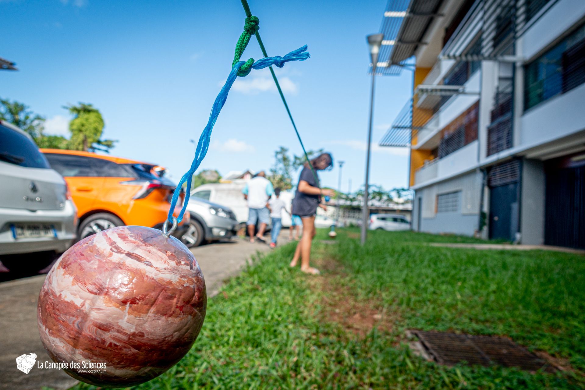 Une grosse boule est suspendue à une corde dans l'herbe.