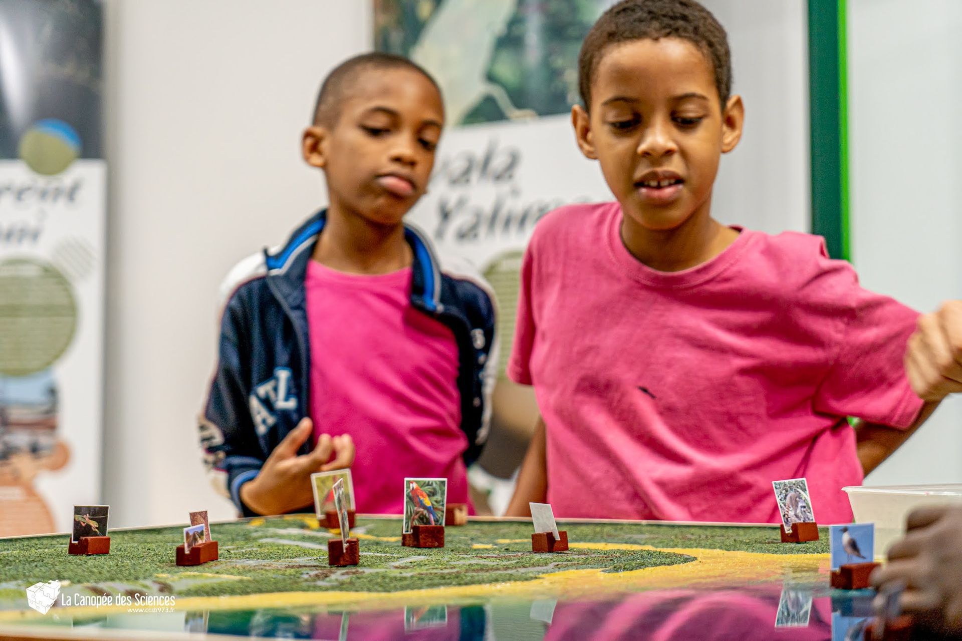 Deux jeunes garçons jouent à un jeu sur une table.