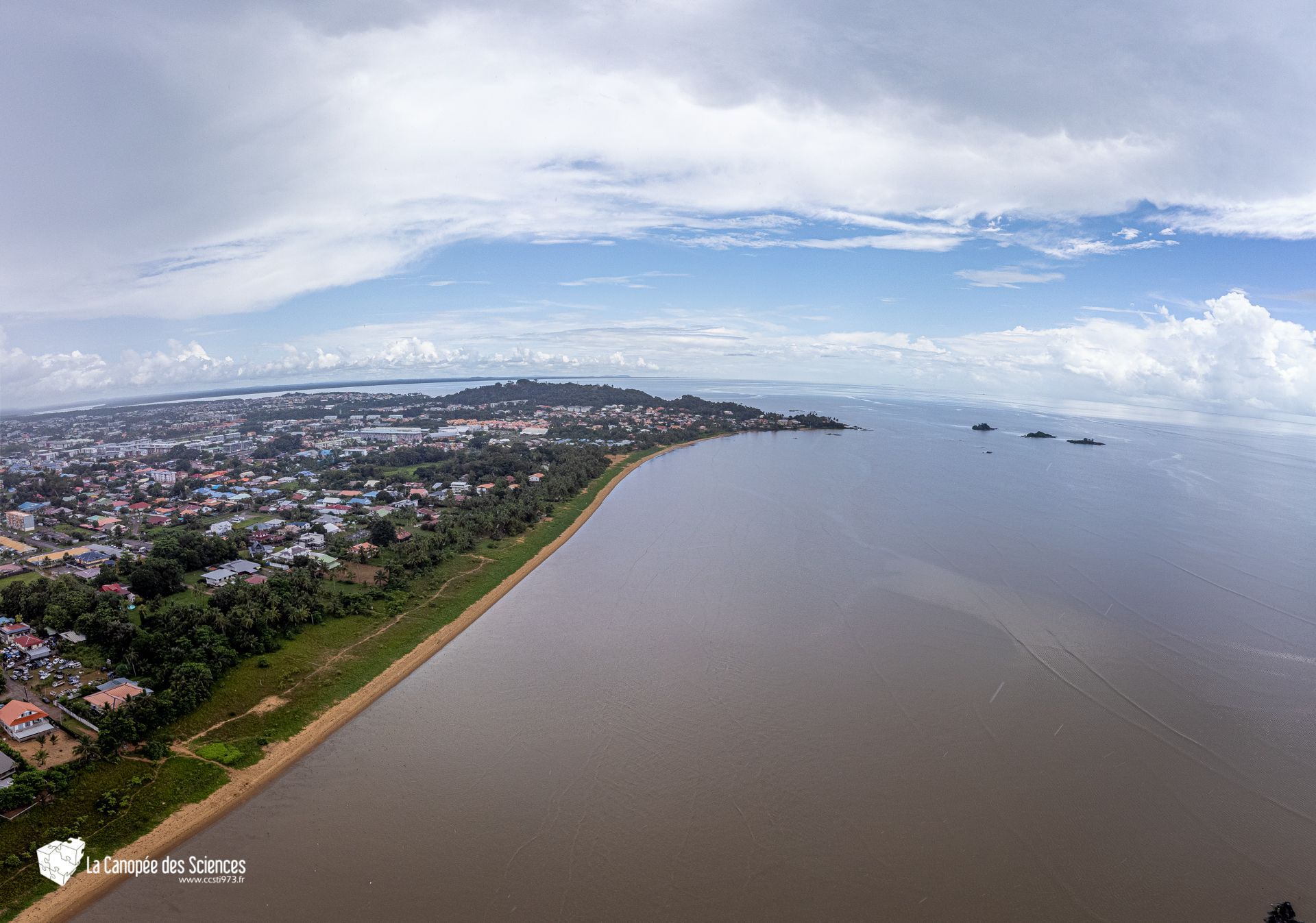 Une vue aérienne d'une grande étendue d'eau avec une ville en arrière-plan.