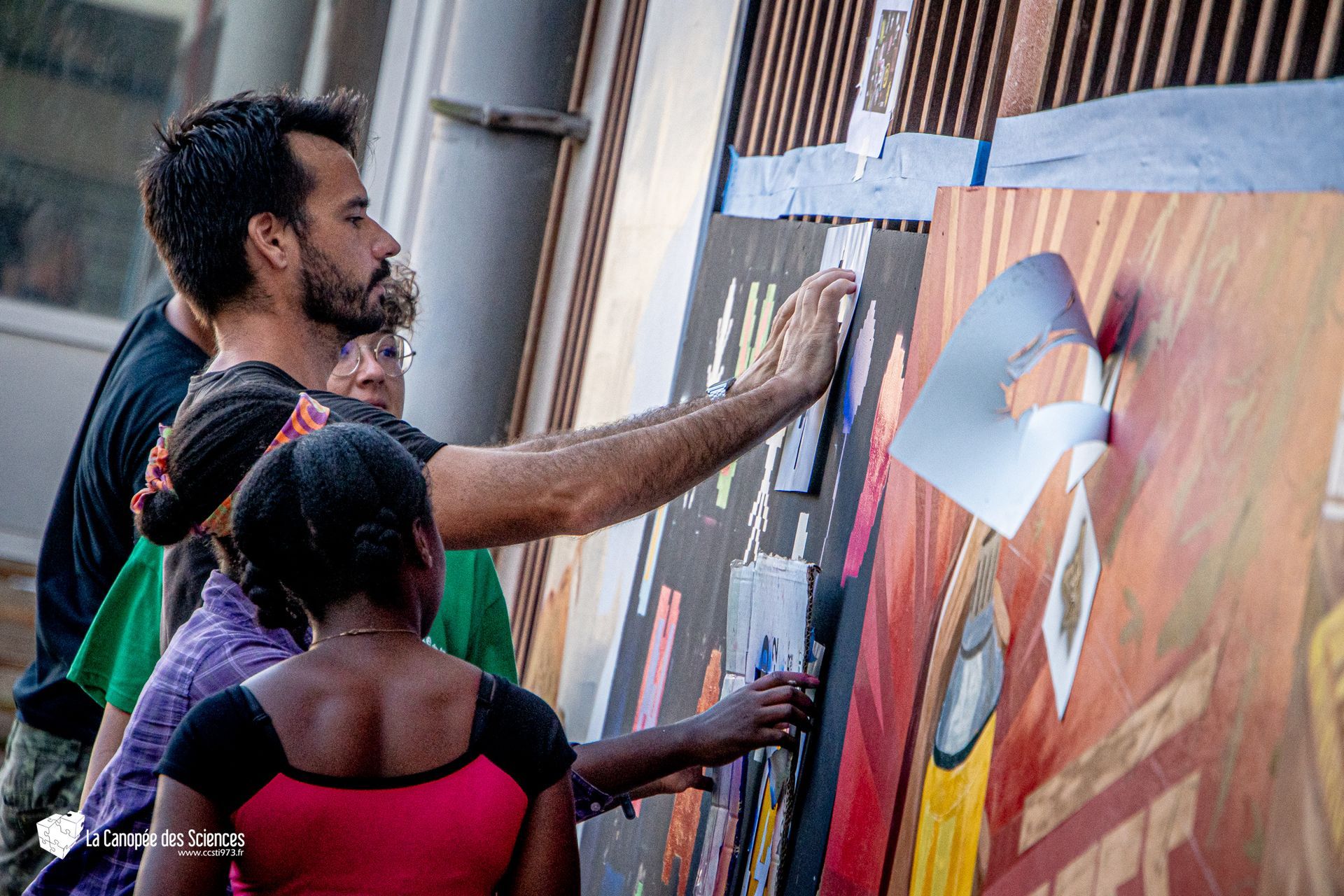 Un groupe de personnes peint une fresque sur un mur.