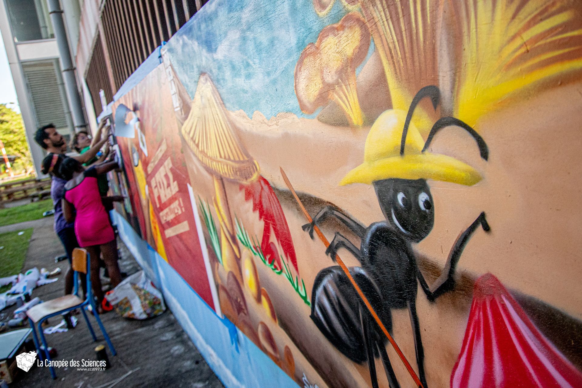 Un groupe de personnes peint une fresque sur un mur.