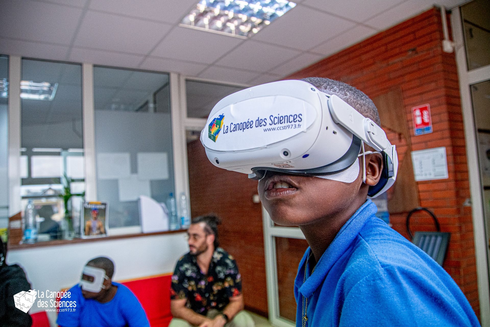Un jeune garçon portant un casque de réalité virtuelle dans une pièce.